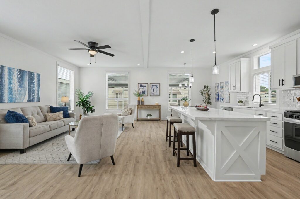 Bright open-concept kitchen and living room with white cabinetry and blue accents